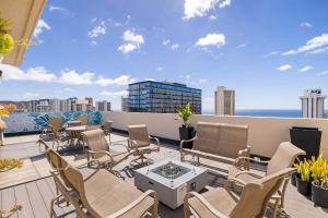 um pátio com cadeiras e uma mesa no telhado em 30 Day Rental In Waikiki With Parking! em Honolulu