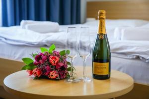 butelkę szampana i dwa kieliszki wina na stole w obiekcie Hotel Pod Zámkem w mieście Boskovice
