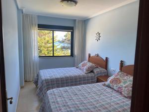 Posteľ alebo postele v izbe v ubytovaní Apartamentos Playa Langosteira