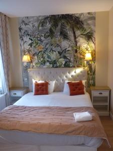 Un dormitorio con una gran cama blanca con almohadas naranjas. en Logis Hôtel Louise de Savoie, en Blois