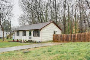 a small white house in a yard with a fence at Mebane Home with Private Yard Steps to Downtown! in Mebane