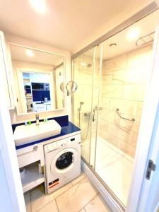 a bathroom with a washing machine and a shower at ORBI CITY sea in Batumi