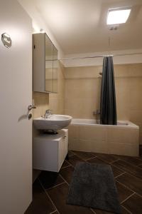 a bathroom with a sink and a bath tub at Flataid Apartments Ludersdorf - voll ausgestattet mit Parkplatz 