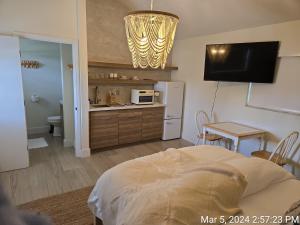 a room with a bed and a kitchen with a refrigerator at Seahorse Beach Bungalows in Fort Pierce