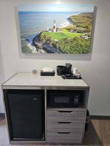 a counter with a microwave and a picture of a lighthouse at 112 Motel in Medford