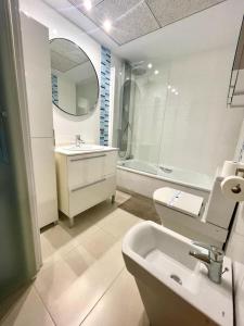 ein Badezimmer mit einem Waschbecken, einem WC und einem Spiegel in der Unterkunft Sea View Apartment Sabbia by Gabbeach in Valencia