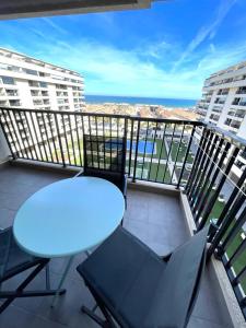 einen Balkon mit einem Tisch, Stühlen und Meerblick in der Unterkunft Sea View Apartment Sabbia by Gabbeach in Valencia
