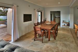 a dining room with a wooden table and chairs at Sandy Feet Langebaan in Langebaan