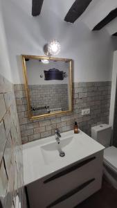 ein Badezimmer mit einem Waschbecken, einem Spiegel und einem WC in der Unterkunft La Casona de Roser in Cardenete