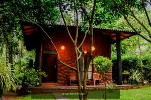 a small house with a grass roof at Wild River Side in Udawalawe
