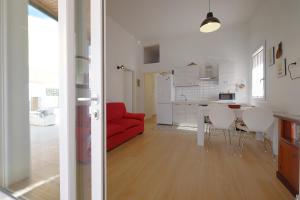 a kitchen and a living room with a red couch at Newly built Holiday House in Teulada in Teulada