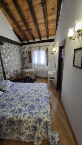 1 dormitorio con cama, mesa y ventana en La Casona de Roser, en Cardenete