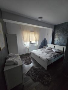 a bedroom with a white bed and a window at DD Residence in Otopeni