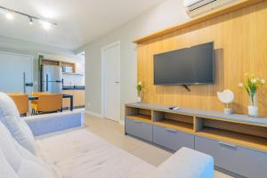 sala de estar con TV en una pared de madera en Parque Shopping #2206 - Apartamento em Boa Viagem Housi por Carpediem en Recife