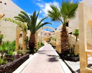 a walkway with palm trees and a building at House Harvey J53 Mareverde in Adeje