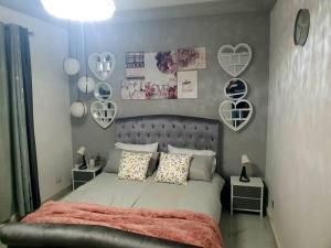 een slaapkamer met een bed met harten aan de muur bij Poolside Garden in Brufut