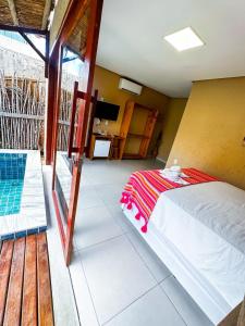um quarto com uma cama e uma varanda em Chalés Milagres Beach em São Miguel dos Milagres