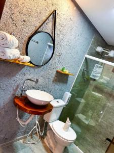 uma casa de banho com um lavatório, um espelho e um WC. em Chalés Milagres Beach em São Miguel dos Milagres