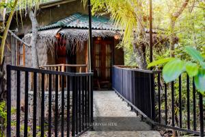 un portail en face d'une maison avec une clôture dans l'établissement Wild River Side, à Uda Walawe