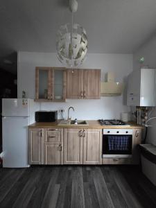 een keuken met houten kasten en een witte koelkast bij DD Residence in Otopeni