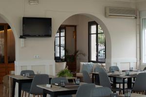 a restaurant with tables and chairs and a flat screen tv at Bahía de Montecarlo in Alcanar