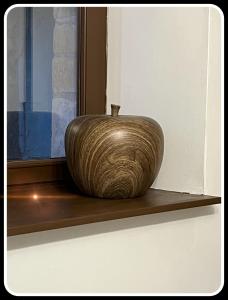 un vase assis sur une étagère à côté d'une fenêtre dans l'établissement La Pomme, à Douvres-la-Délivrande