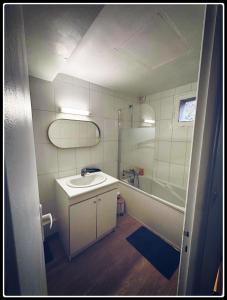 La salle de bains est pourvue d'un lavabo, d'une douche et d'une baignoire. dans l'établissement La Pomme, à Douvres-la-Délivrande