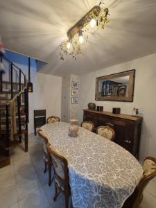 uma sala de jantar com uma mesa e cadeiras e um lustre em La Pomme em Douvres-la-Délivrande