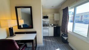 a small kitchen with a table and a mirror at Americas Best Value Inn New London Mystic in New London