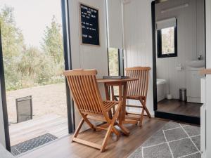 Mahana的住宿－Bronte Tiny House，一间带两把椅子和一张桌子的用餐室