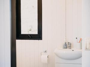 a bathroom with a sink and a window at Bronte Tiny House in Mahana