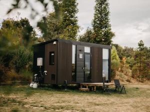 a tiny house sitting on top of a field at Bronte Tiny House in Mahana