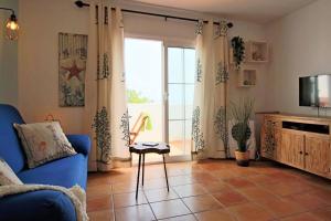 Una sala de estar con un sofá azul y un televisor. en Marisco, céntrico con terraza, en Playa Blanca