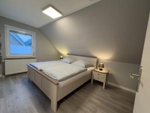a bedroom with a bed and a window at Windfang 1 in Hooksiel in Wangerland