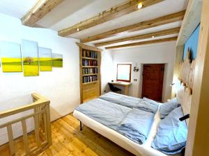 1 dormitorio con cama y estante para libros en Nostalgie di un tempo nelle Dolomiti, en Pergine Valsugana