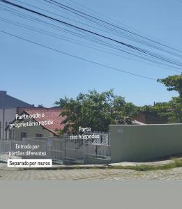 un cartel en una valla delante de un edificio en Casa de Praia Armacao de Itapocoroi 261 - Próximo ao Parque Beto Carrero World, en Penha