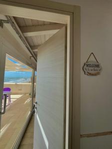 a door to a balcony with a view of the ocean at HOLIDAY HOME AURORABIO- locazione turistica breve in Tre Fontane