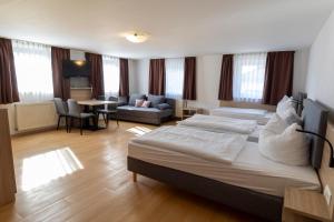 ein Hotelzimmer mit einem Bett und einem Wohnzimmer in der Unterkunft Hotel Landgasthaus Rössle in Hofweier