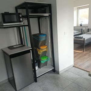 Cette chambre comprend un réfrigérateur noir et un four micro-ondes. dans l'établissement Agroturystyka pod niebieskim dachem, à Siedlęcin