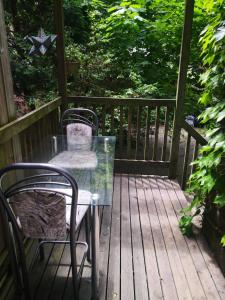 a glass table and chairs on a wooden deck at Spacious Room next to Subway Line 1 Midtown Toronto in Toronto