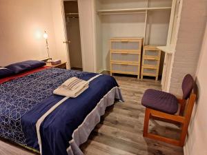 a bedroom with a blue bed and a chair at Spacious Room next to Subway Line 1 Midtown Toronto in Toronto