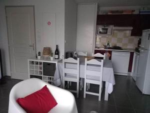 - une cuisine avec une table et un oreiller rouge dans l'établissement Maison de vacances Aubignan, à Aubignan