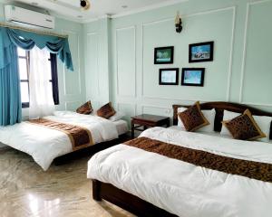 2 camas en una habitación con paredes azules en NHÀ NGHỈ-HOMESTAY -KHÁCH SẠN ĐỒNG VĂN Hà Giang, en Dồng Văn