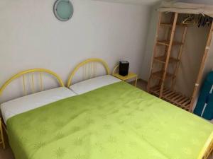a bedroom with a green blanket on a bed at Maison de vacances Aubignan in Aubignan +10 photos