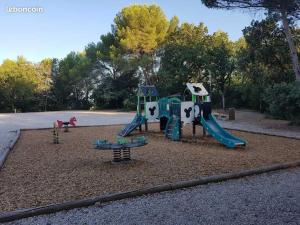 a playground with a slide in a park at Maison de vacances Aubignan in Aubignan