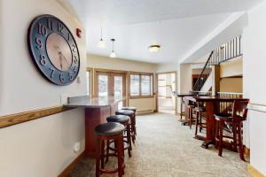 a bar with stools and a clock on the wall at Phoenix 128S in Steamboat Springs