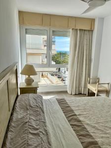 a bedroom with a bed and a large window at Bello Horizonte Apartman 4B in Salou