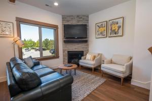 a living room with a leather couch and a fireplace at Suncadia 2 Bdrm Village Chalet Contemporary Cabin in Cle Elum