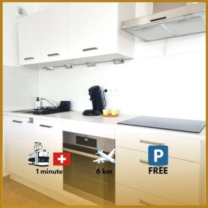 a kitchen with white cabinets and a stove top oven at Le frontalier appart in Saint-Louis