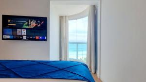 een slaapkamer met een bed en een groot raam bij Wyndham Rio Barra in Rio de Janeiro